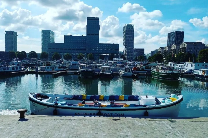 a small boat in a body of water with a city in the background