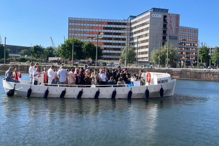 a group of people standing next to a body of water