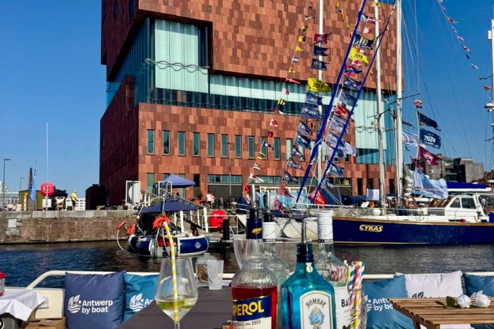 Drinks on a boat with a brick building and sailboats in the background.